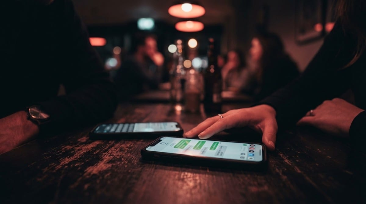 Two smartphones placed on table during date conversation showing lack of meaningful engagement