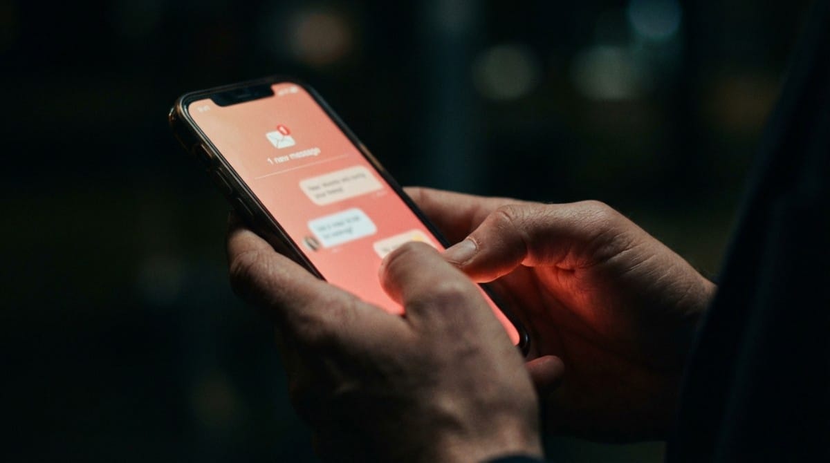 Close-up of smartphone showing new message notification in dark setting